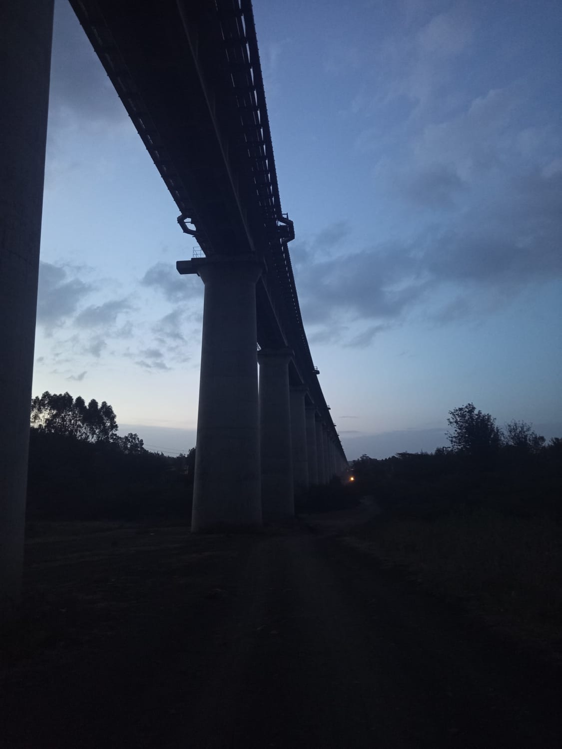 A dramatic, low-angle shot of the same railway viaduct at dusk.